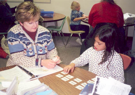 student and instructor sitting at table with flashcards