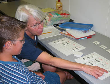 Adult pointing to a sheet of paper with flashcards
